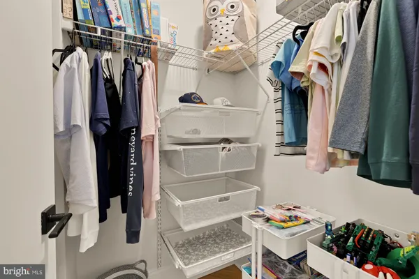 a view of walk in closet with clothes and shoes