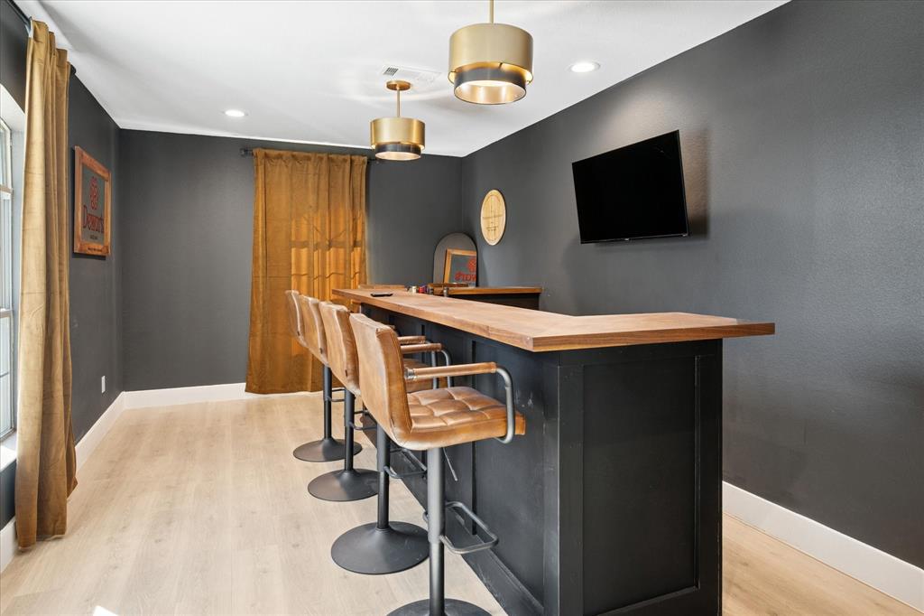 437 South 1st Street Krum, TX 76249 - Photo 14 of 38 a bedroom with a bed and a flat screen tv