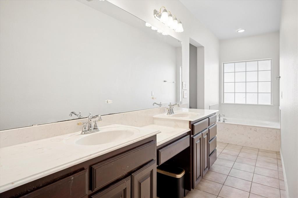 437 South 1st Street Krum, TX 76249 - Photo 21 of 38 a bathroom with a sink double vanity and a bathtub