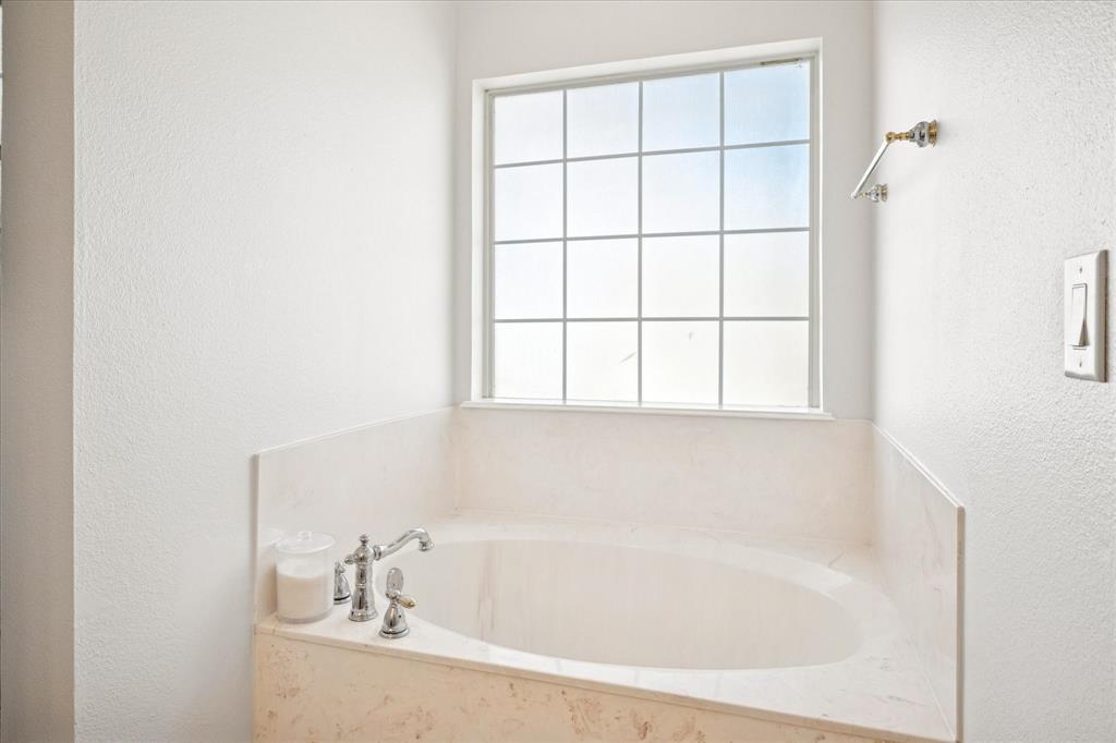 437 South 1st Street Krum, TX 76249 - Photo 22 of 38 a white bath tub sitting next to a window
