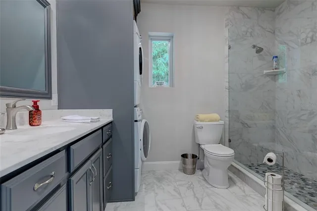 a bathroom with a granite countertop sink a toilet and a mirror