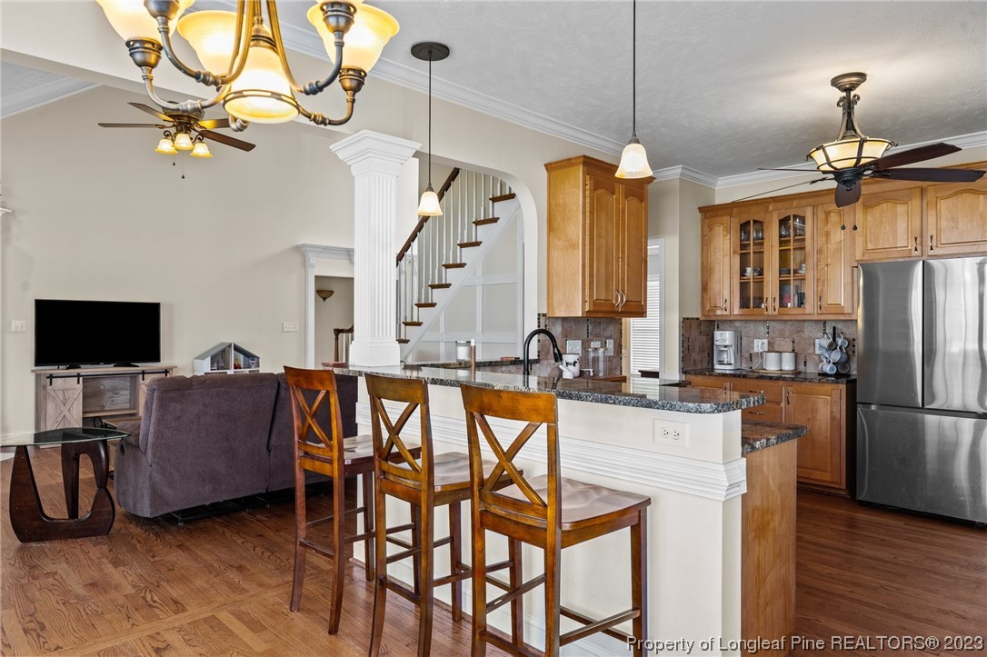 6407 Cattesmore Road Fayetteville, NC 28311 - Photo 17 of 42 a view of a dining room with furniture a chandelier and wooden floor