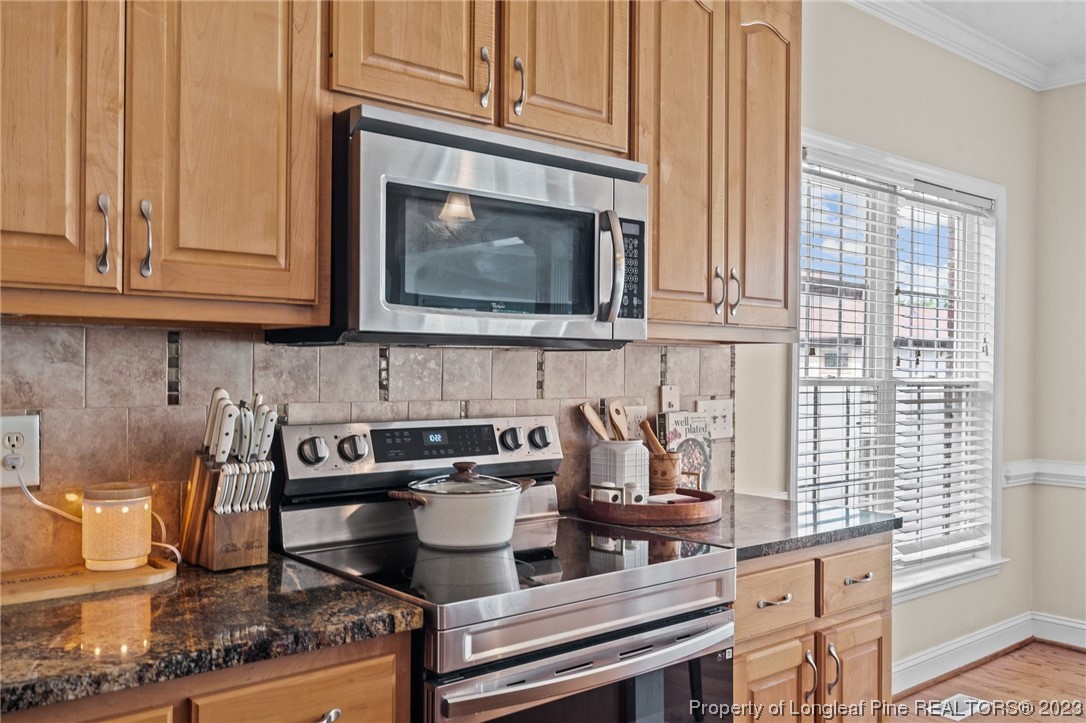 6407 Cattesmore Road Fayetteville, NC 28311 - Photo 21 of 42 a kitchen with granite countertop a stove a sink and a microwave