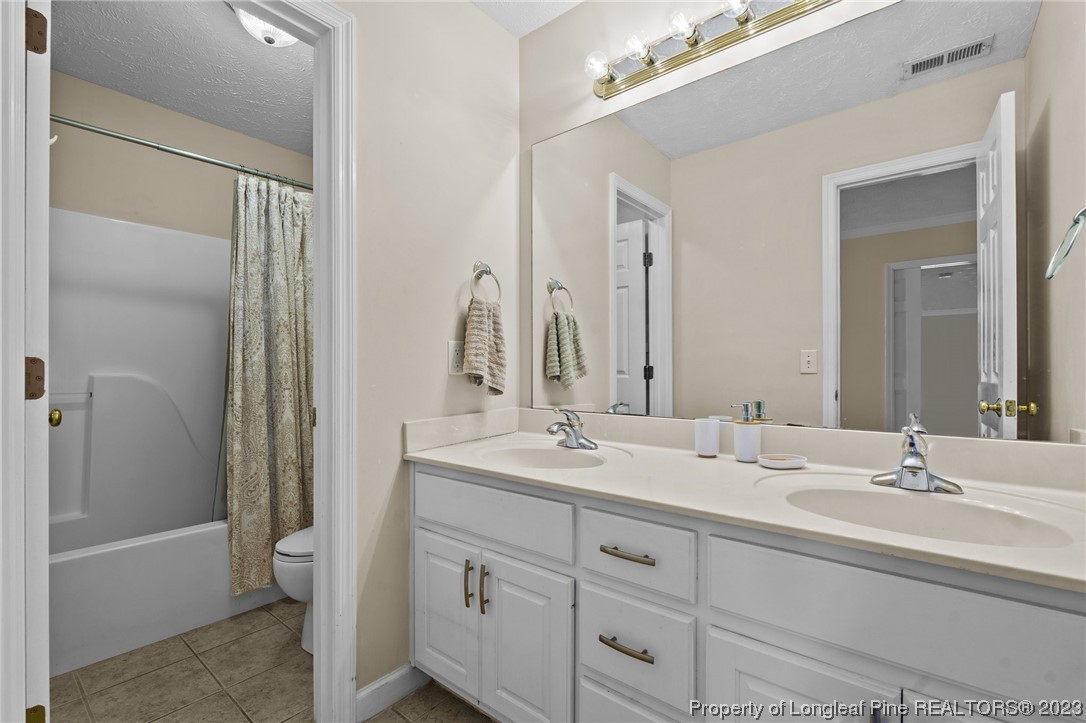 6407 Cattesmore Road Fayetteville, NC 28311 - Photo 28 of 42 a bathroom with a double vanity sink and mirror with shower