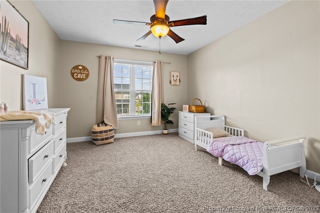 6407 Cattesmore Road Fayetteville, NC 28311 - Photo 30 of 42 a bedroom with bed and a chandelier