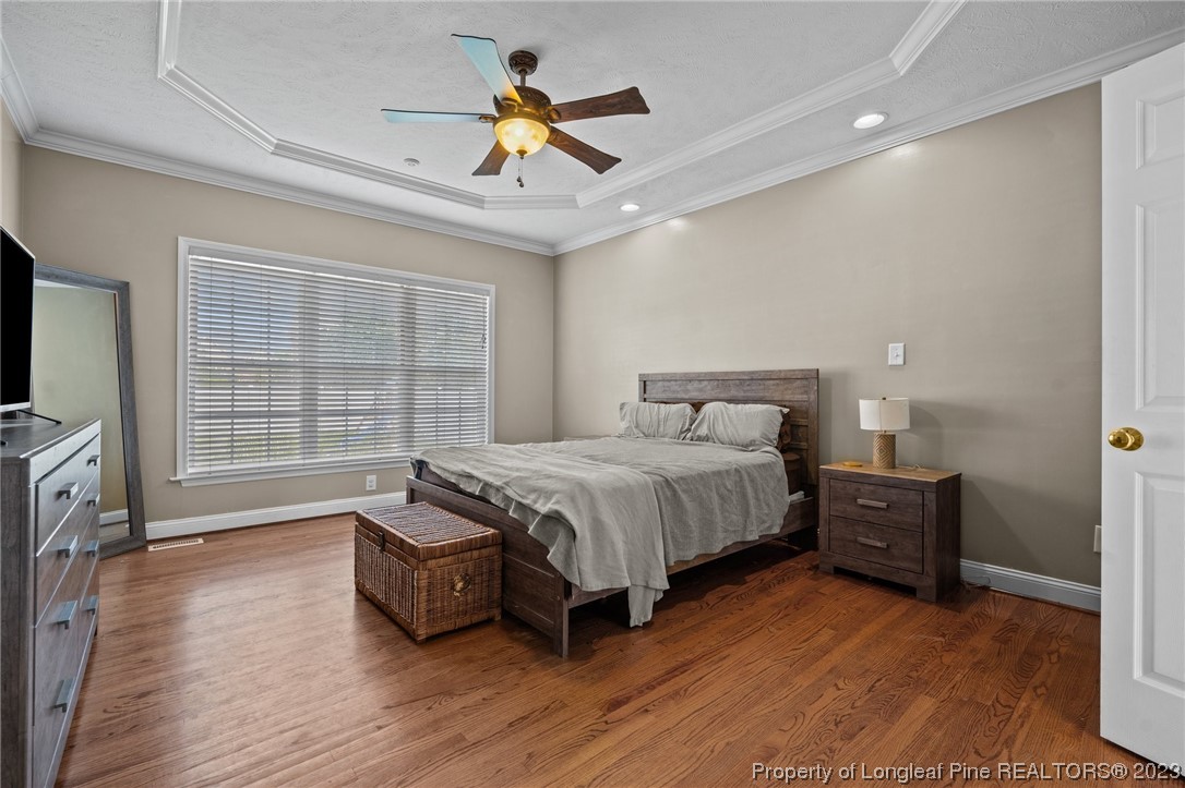 6407 Cattesmore Road Fayetteville, NC 28311 - Photo 4 of 42 a spacious bedroom with a bed and a chandelier