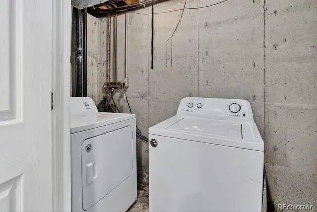 a view of an empty room with wooden floor and stairs