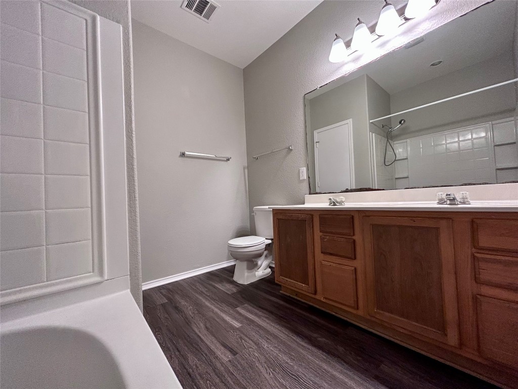 8916 Ipswich Bay Drive Austin, TX 78747 - Photo 19 of 39 a spacious bathroom with a double vanity sink a toilet and a mirror