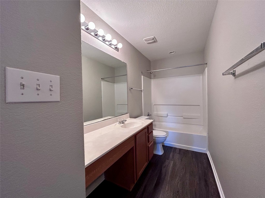 8916 Ipswich Bay Drive Austin, TX 78747 - Photo 34 of 39 a bathroom with a sink a toilet a mirror and vanity