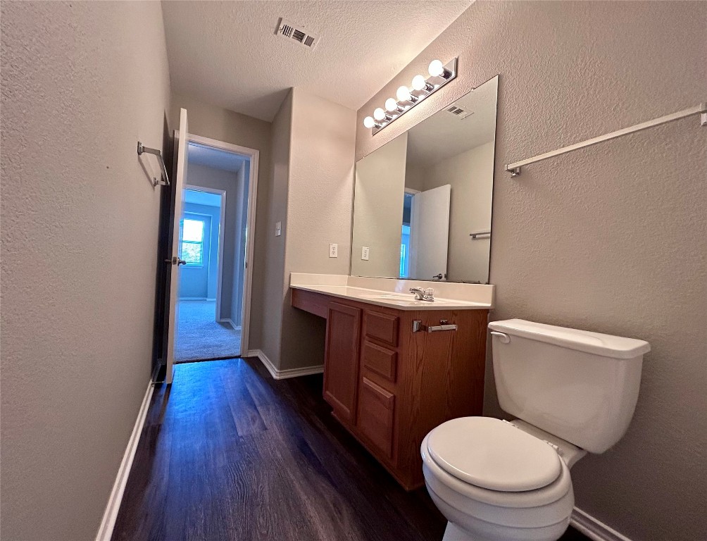 8916 Ipswich Bay Drive Austin, TX 78747 - Photo 35 of 39 a bathroom with a toilet a sink and mirror