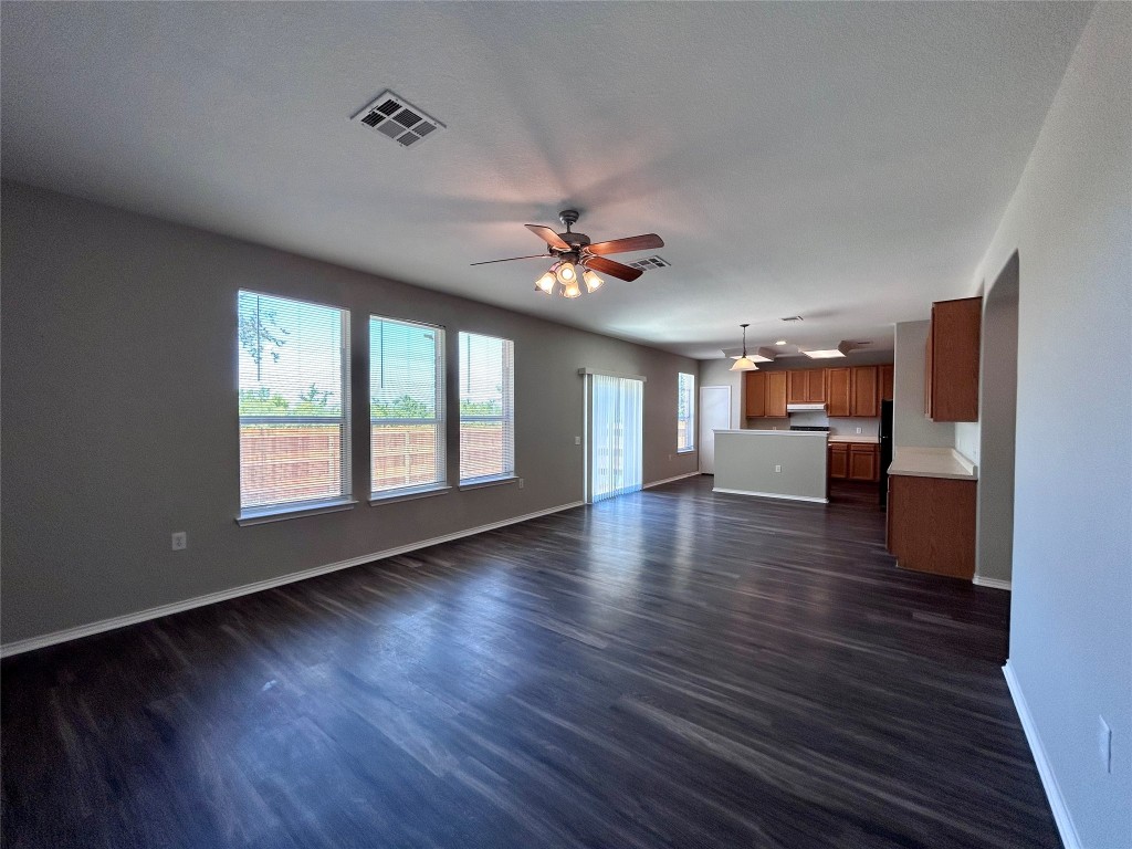 8916 Ipswich Bay Drive Austin, TX 78747 - Photo 9 of 39 a view of an empty room with a kitchen and wooden floor