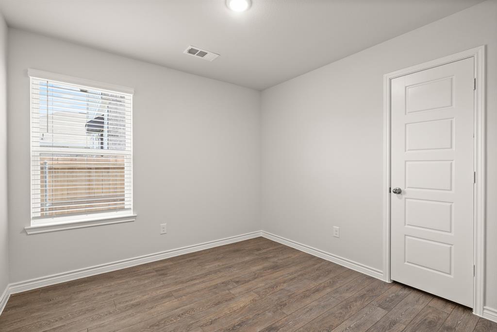 1508 Romans Road Ennis, TX 75119 - Photo 11 of 19 a view of an empty room with wooden floor and a window
