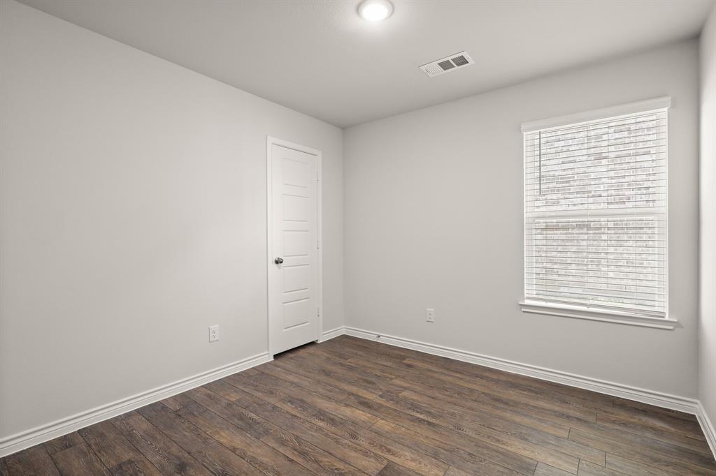 1508 Romans Road Ennis, TX 75119 - Photo 15 of 19 an empty room with wooden floor and windows