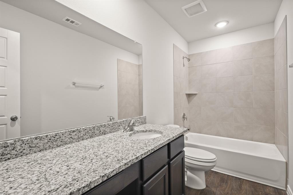 1508 Romans Road Ennis, TX 75119 - Photo 17 of 19 a bathroom with a granite countertop sink toilet and shower