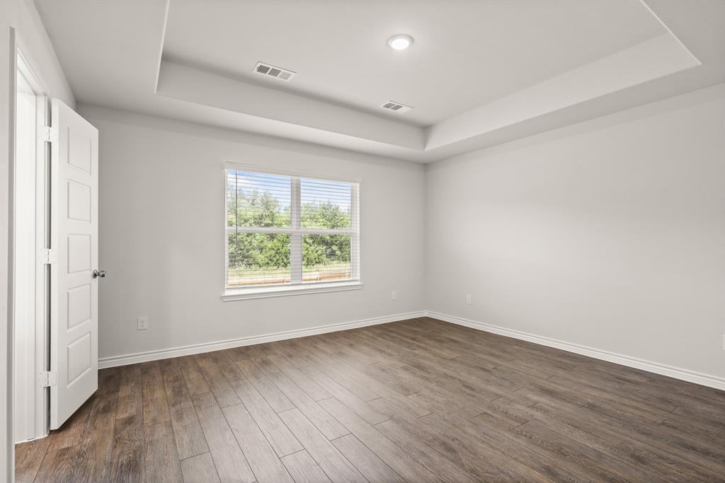 1508 Romans Road Ennis, TX 75119 - Photo 8 of 19 an empty room with wooden floor and windows