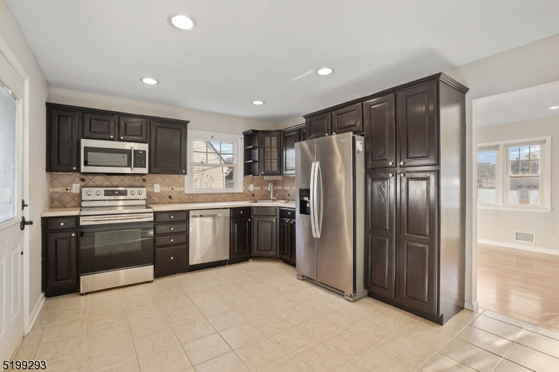 8 Corsi Road Bloomfield, NJ 07003 - Photo 4 of 11 a large kitchen with cabinets and stainless steel appliances