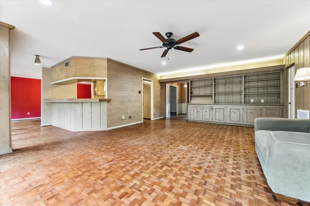 a view of a livingroom with wooden floor and a ceiling fan