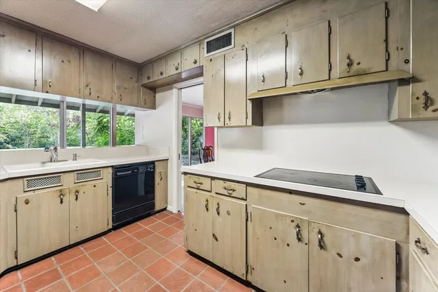 a kitchen with white cabinets a sink dishwasher and a stove