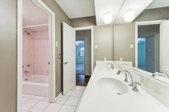 a bathroom with a tub sink and mirror