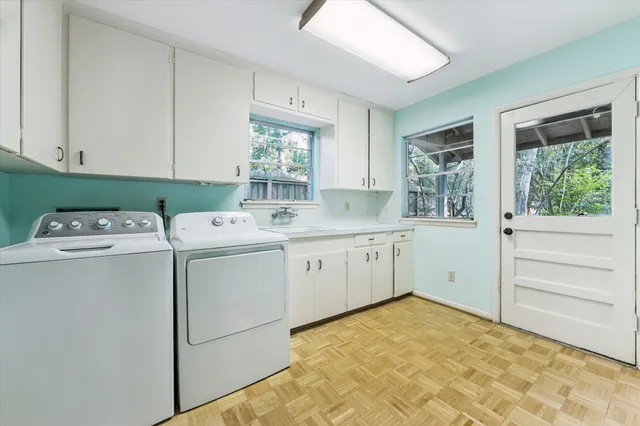 a utility room with cabinets washer and dryer