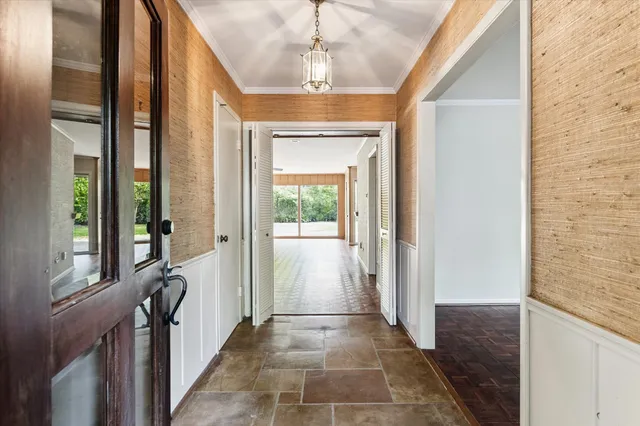 a view of a hallway to a livingroom with furniture