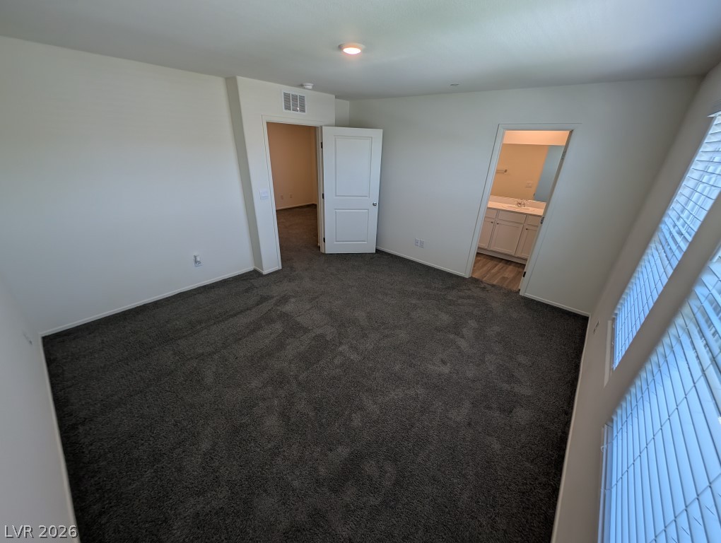 4820 Orchid Rdg Avenue Las Vegas, NV 89141 - Photo 17 of 27 A spacious bedroom features soft, neutral carpeting, offering a tranquil retreat.
