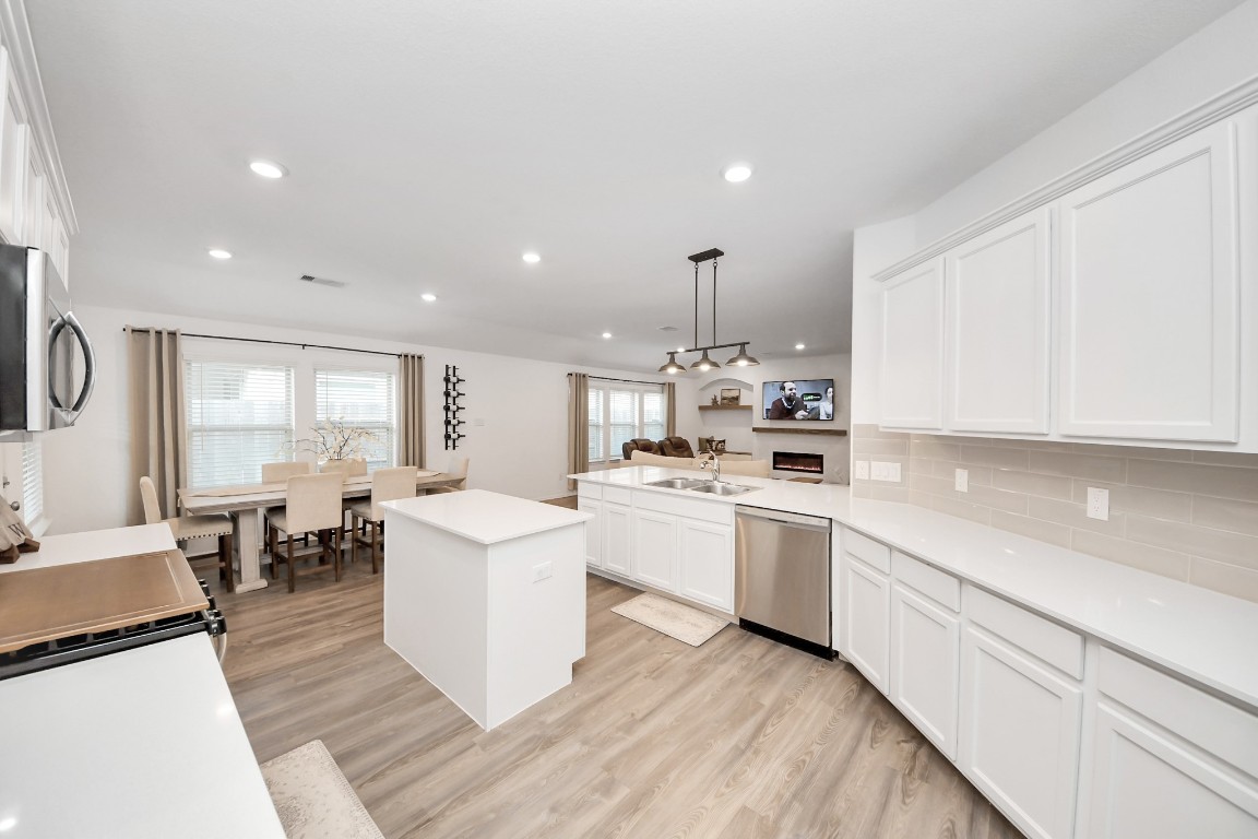 2835 Mistygate Court Conroe, TX 77301 - Photo 12 of 35 Open-concept design connects the kitchen to both dining and living spaces, creating a natural gathering area.