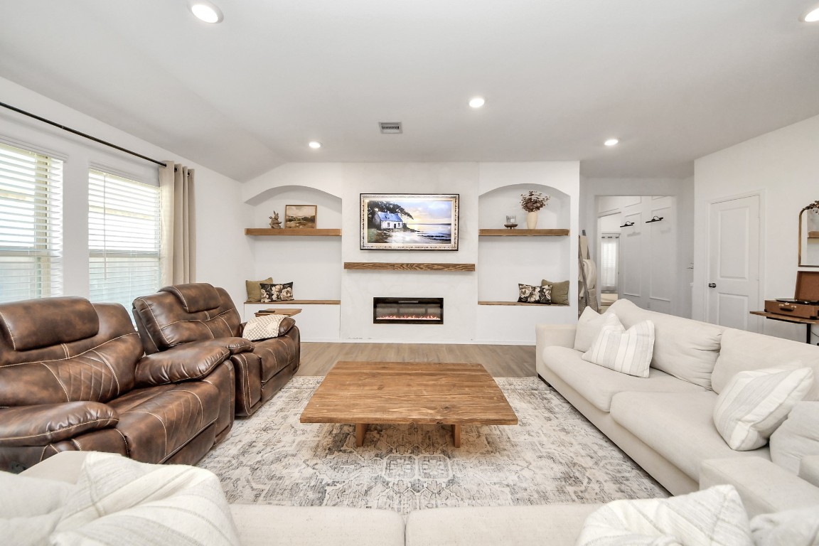 2835 Mistygate Court Conroe, TX 77301 - Photo 6 of 35 Inviting living space centered around a modern fireplace with built-in shelving, creating the perfect spot to relax or entertain.