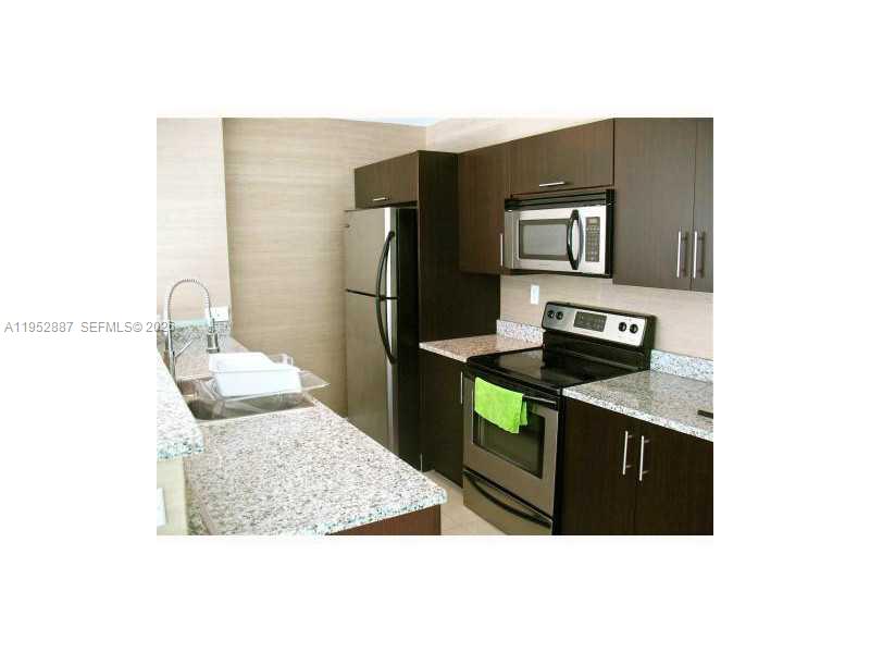 2694 Inagua Avenue, Unit 303 Coconut Grove, FL 33133 - Photo 11 of 18 a kitchen with stainless steel appliances kitchen island a refrigerator sink and stove