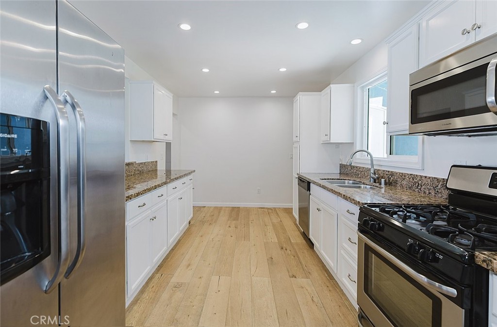 17134 Sherman Way Lake Balboa, CA 91406 - Photo 13 of 27 a large kitchen with stainless steel appliances granite countertop a stove and a refrigerator