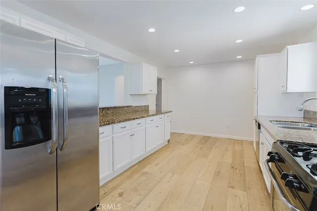 a kitchen with stainless steel appliances granite countertop a refrigerator and a stove