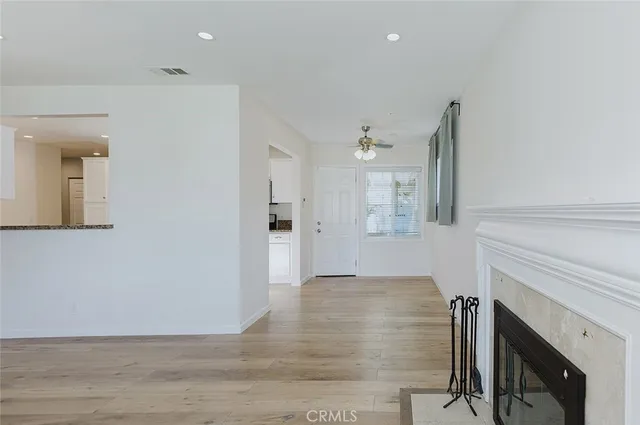 a view of a livingroom with wooden floor and a fireplace