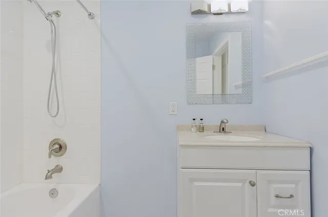 a bathroom with a sink a vanity and a bathtub