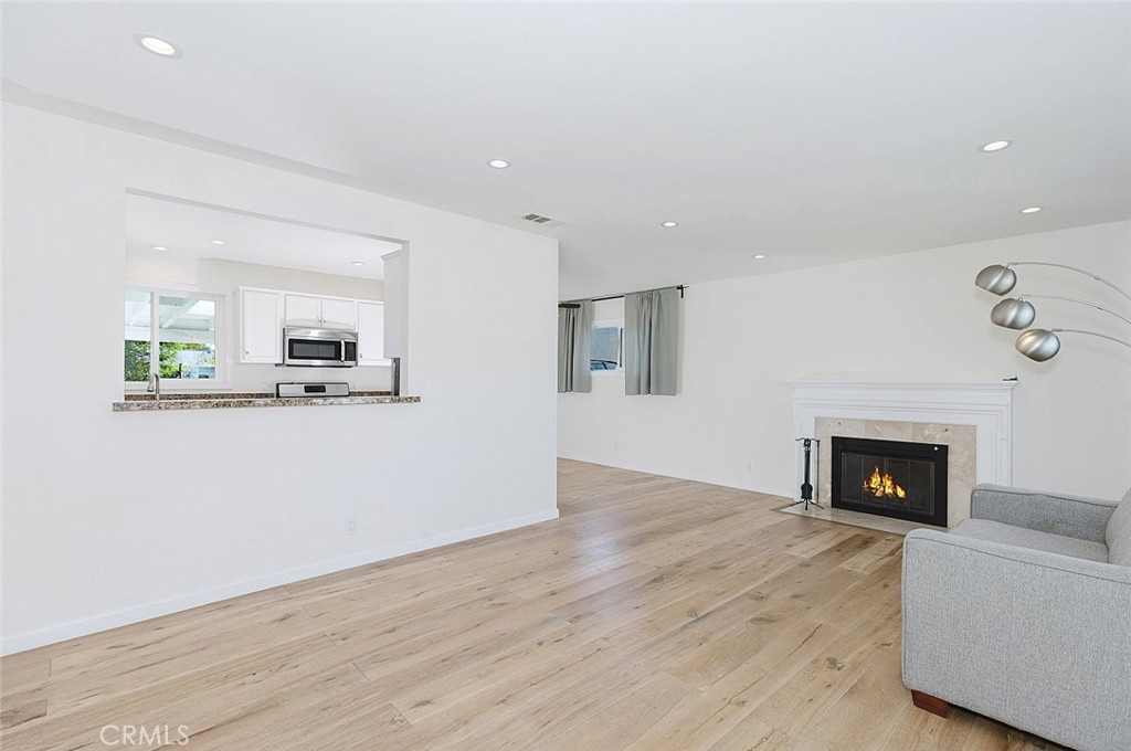 17134 Sherman Way Lake Balboa, CA 91406 - Photo 10 of 27 a living room with stainless steel appliances furniture a fireplace and wooden floor