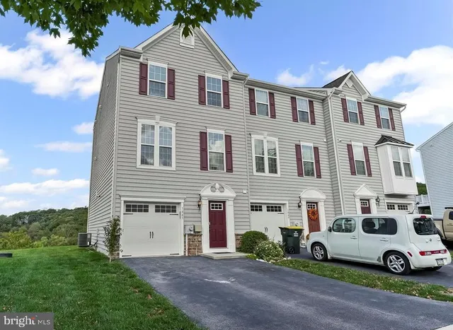 a white house with a yard and parking space