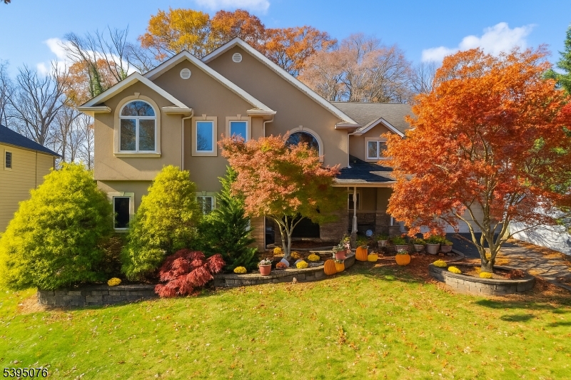 a view of a house with a big yard and large trees