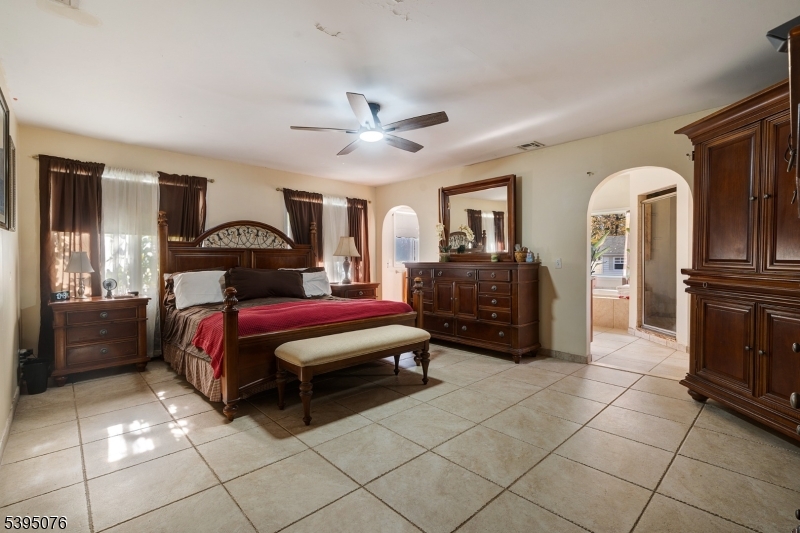 24 Woodland Road Clark, NJ 07066 - Photo 12 of 45 a spacious bedroom with a bed a dresser and mirror
