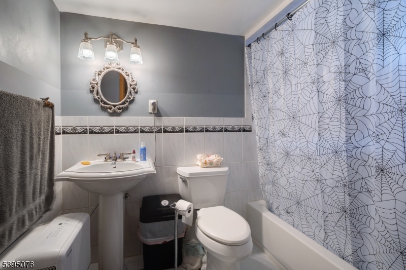 24 Woodland Road Clark, NJ 07066 - Photo 16 of 45 a bathroom with a toilet a sink and mirror