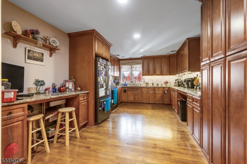 24 Woodland Road Clark, NJ 07066 - Photo 18 of 45 a kitchen with stainless steel appliances granite countertop a refrigerator a stove a sink dishwasher and a oven with wooden floor