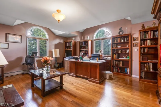 a living room with furniture a lamp and book shelf