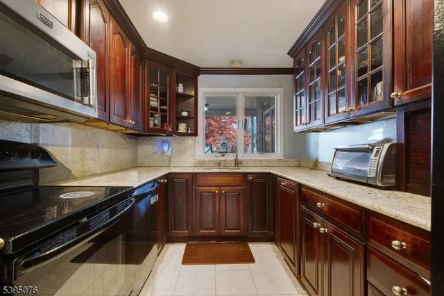 a kitchen with stainless steel appliances granite countertop a sink stove and microwave