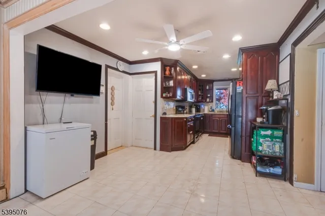 a living room with stainless steel appliances furniture and a flat screen tv