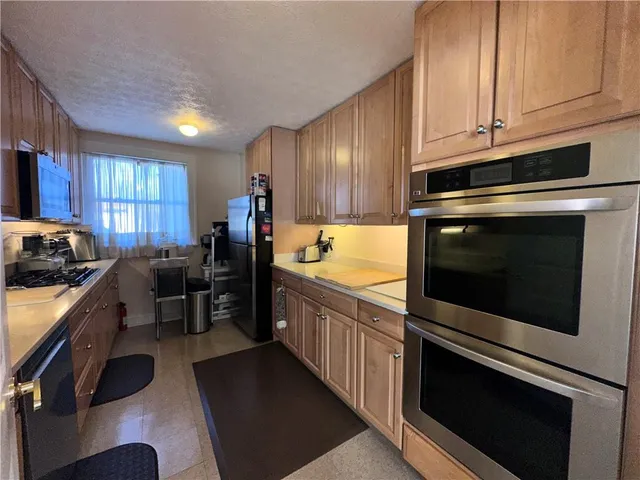 a kitchen with stainless steel appliances a stove a sink and a microwave