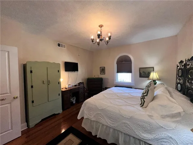 a bedroom with a bed and a chandelier