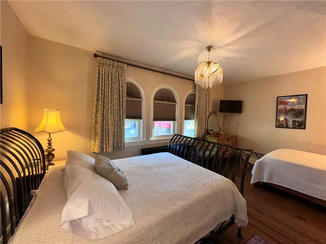 a bedroom with bed and a chandelier