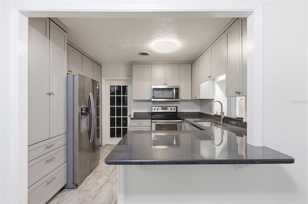 1291 Oxford Road Maitland, FL 32751 - Photo 11 of 37 a kitchen with kitchen island a counter top space a sink stainless steel appliances and cabinets