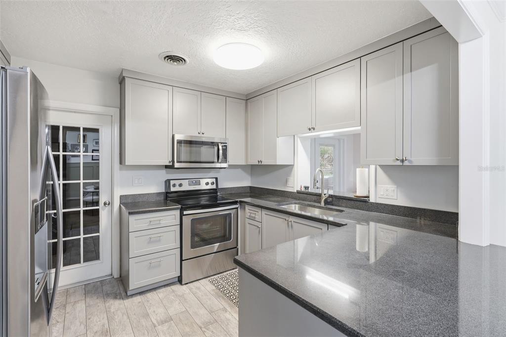 1291 Oxford Road Maitland, FL 32751 - Photo 12 of 37 a kitchen with granite countertop a sink stainless steel appliances and cabinets