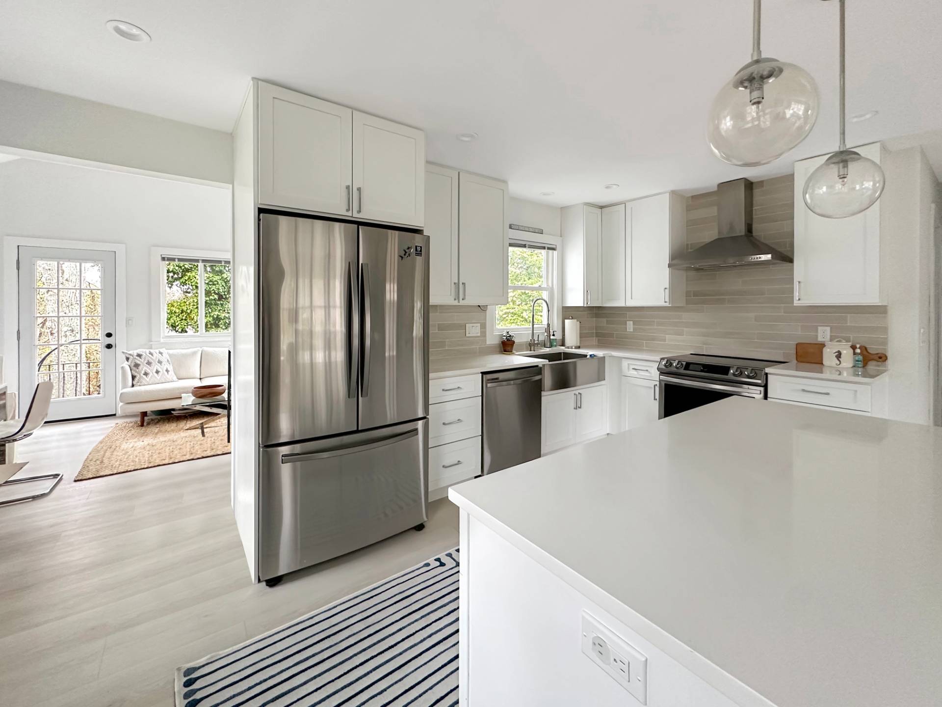 23 Bittersweet Avenue Hampton Bays, NY 11946 - Photo 4 of 17 a kitchen with granite countertop a refrigerator a stove a sink dishwasher a dining table and chairs with wooden floor