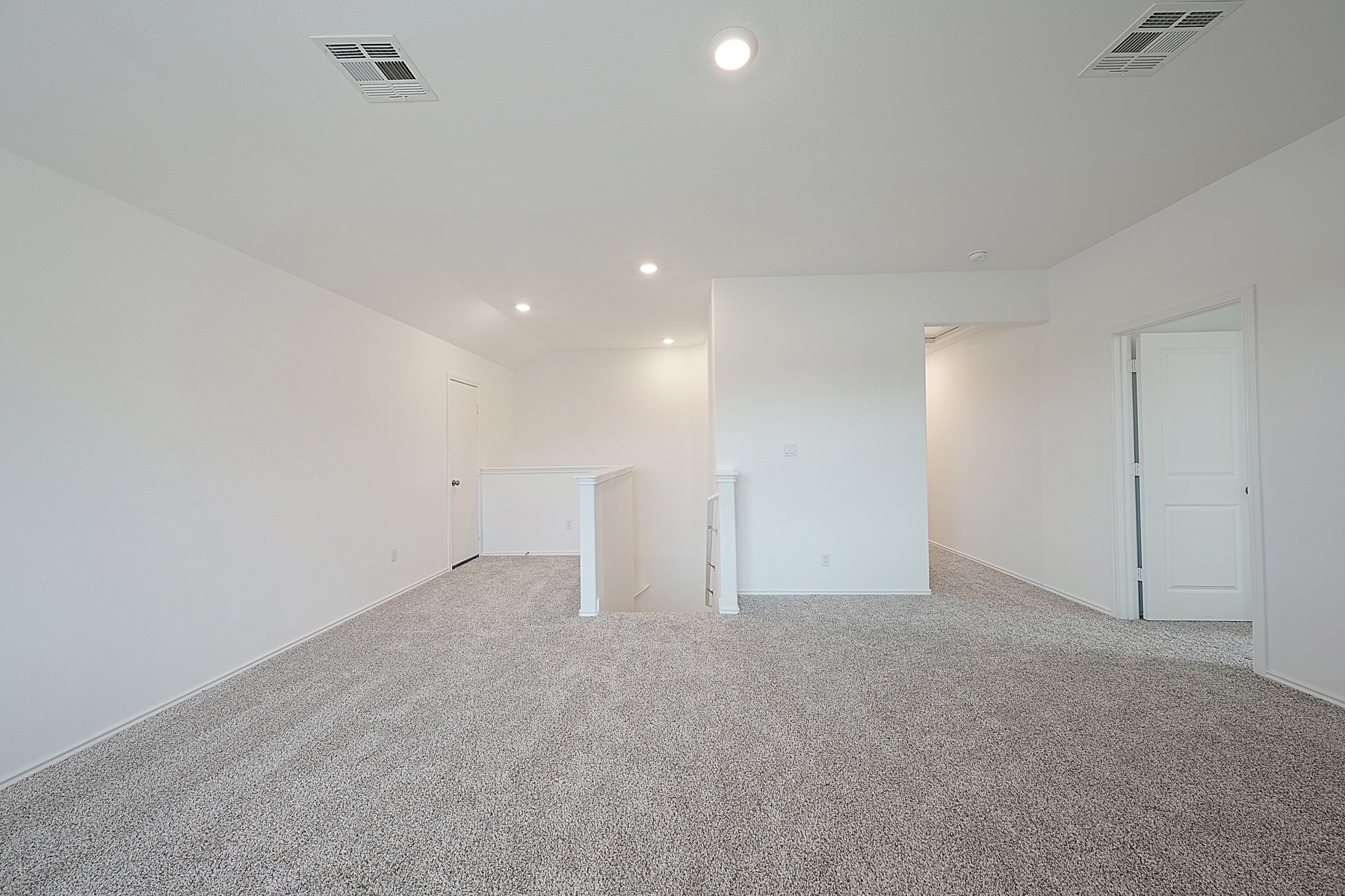 932 Mallow Road Leander, TX 78641 - Photo 24 of 34 A spacious, carpeted area with bright recessed lighting offers versatile living space.