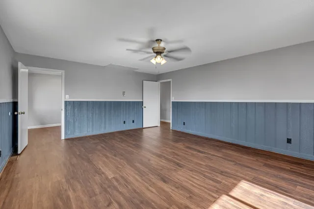 wooden floor in an empty room with a kitchen